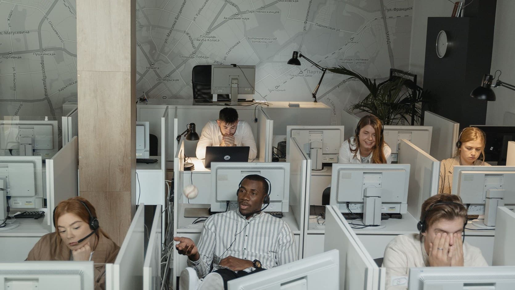 Sales floor with customer sales representatives making calls on headsets in cubicles